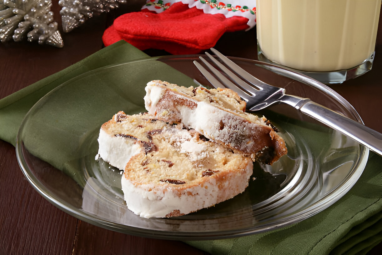 Two slices of a dessert on a glass plate with a fork, set on a green napkin.
