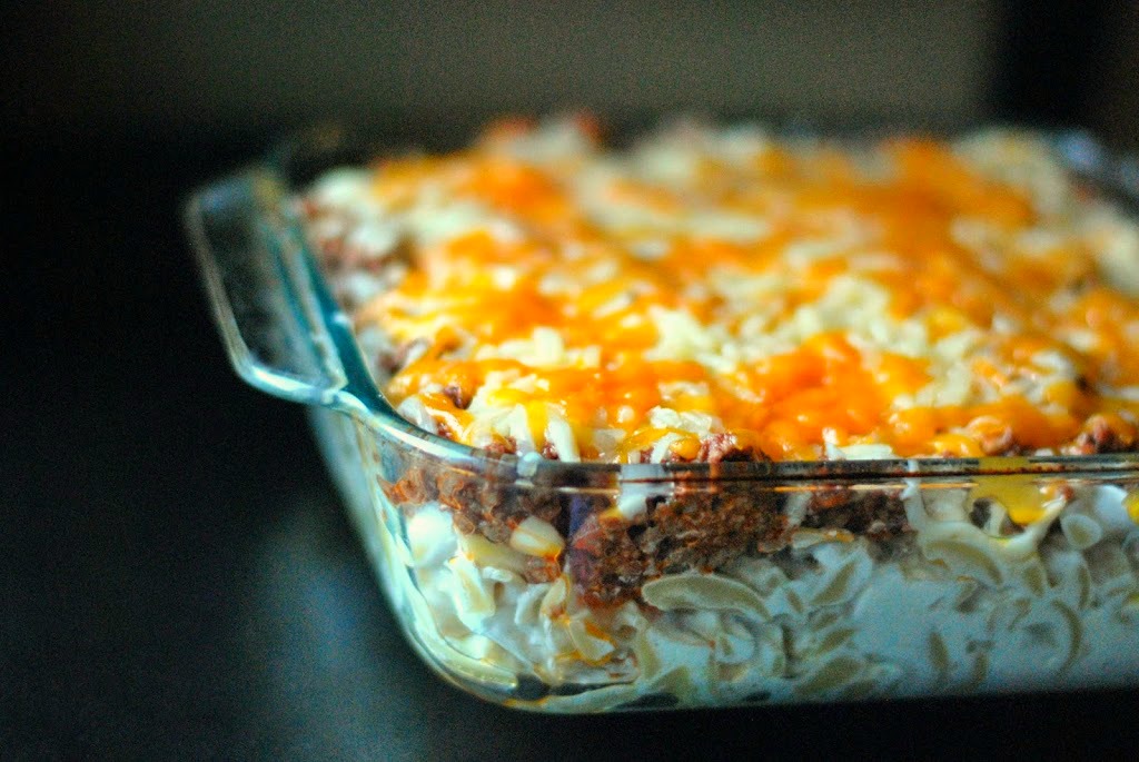 A close-up view of a baked casserole in a glass dish topped with melted cheese